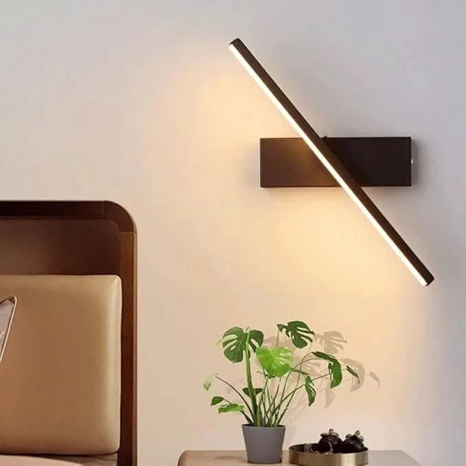 Ambiance chambre avec applique orientée en diagonale éclairant un mur beige
