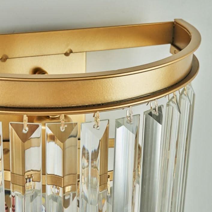 Gros plan sur l'armature métallique dorée et la fixation des pendentifs en cristal