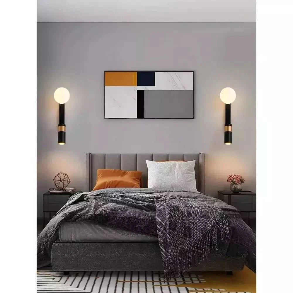 Deux appliques identiques encadrant un lit sous un tableau géométrique