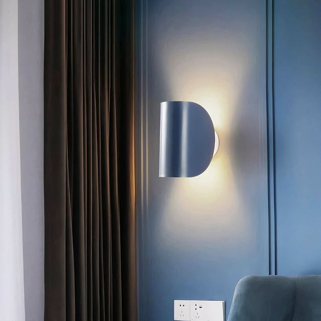 Mise en ambiance de l'applique bleue allumée sur mur bleu près d'un rideau