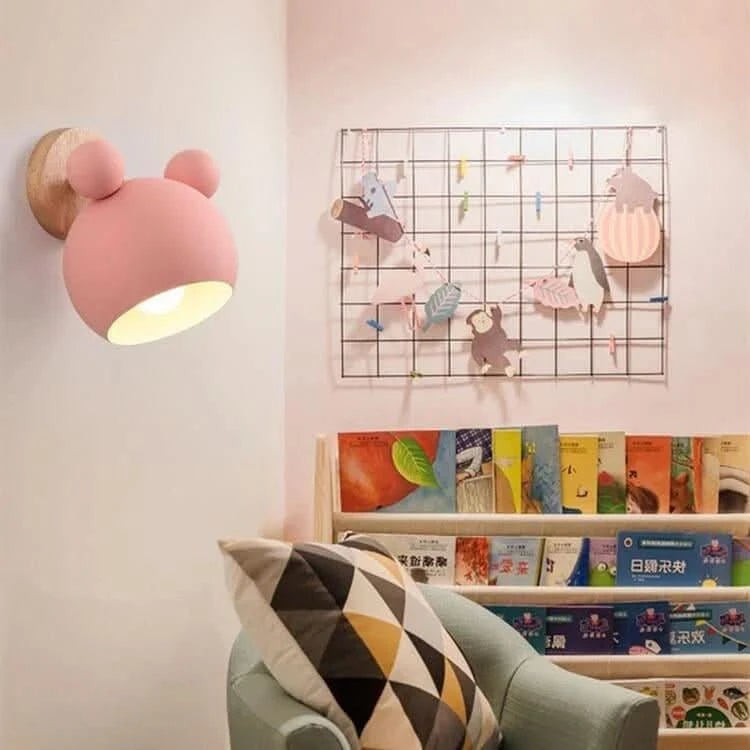 Applique rose allumée au-dessus d'une bibliothèque dans une chambre d'enfant