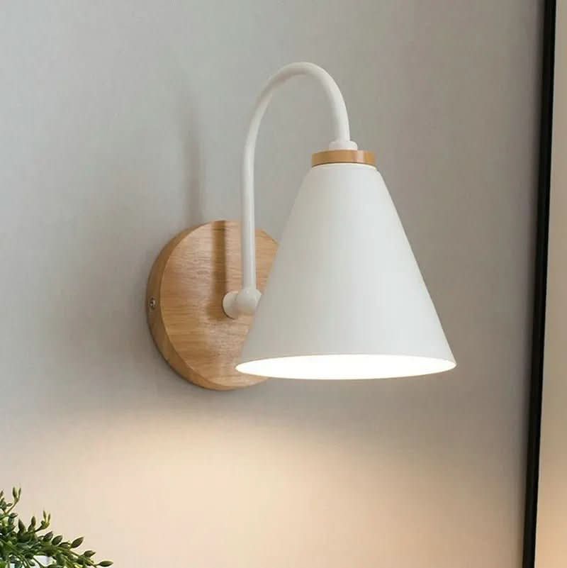 Version blanc mat allumée, bras courbé et diffuseur conique sur fond de mur beige