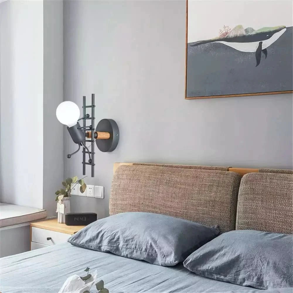 Vue en situation dans une chambre : applique noire à côté d'un lit et d'un tableau.