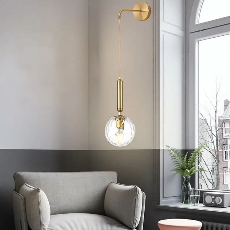 Détail d'une variante dorée à boule de verre transparent côtelé laissant apparaître l'ampoule