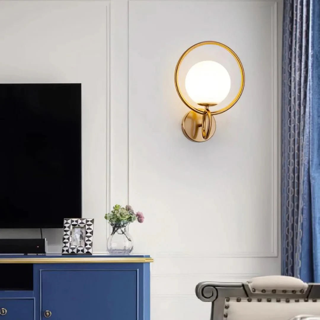 Applique dorée installée sur un mur blanc près d'un meuble bleu