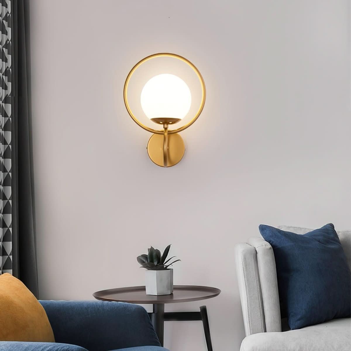Version dorée allumée de l'applique, dans un salon au canapé bleu