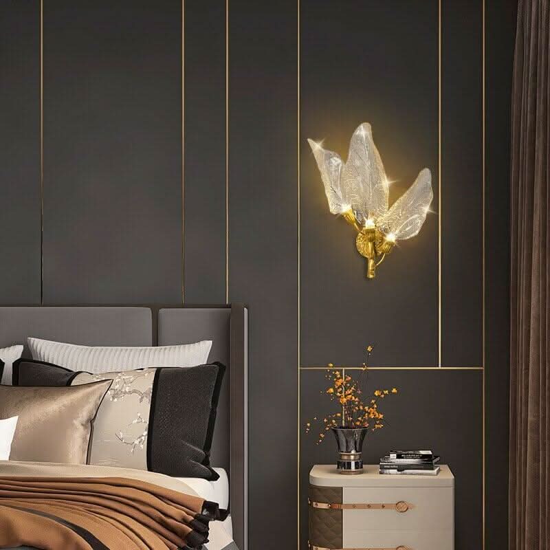 Mise en ambiance chambre avec applique dorée au-dessus d'un chevet clouté