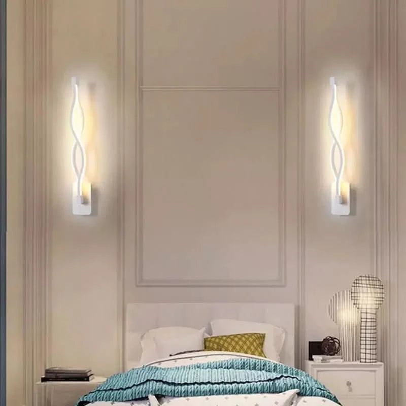 Deux appliques fines torsadées encadrent le lit sur une cloison à moulures blanches