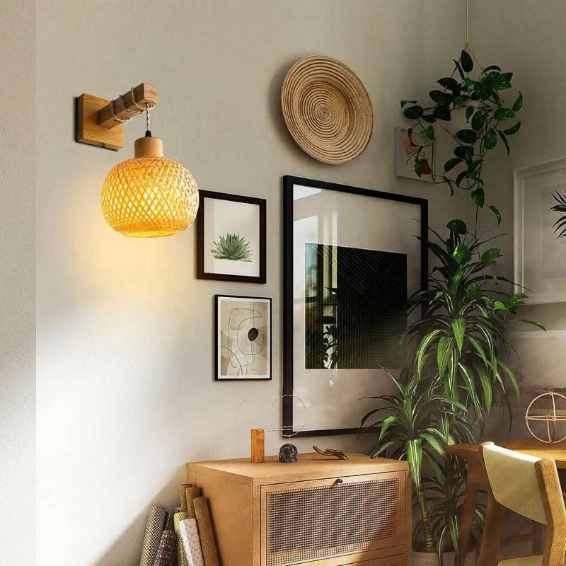 Mise en ambiance dans un salon avec cadres, plante verte et meuble cannage