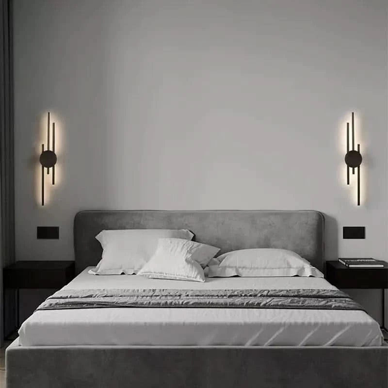 Deux appliques noires symétriques encadrent la tête de lit dans une chambre grise