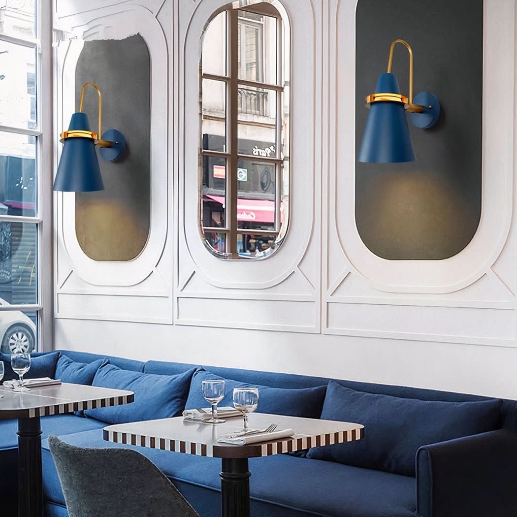 Appliques bleues installées dans un café, miroirs en arche et banquette en velours.