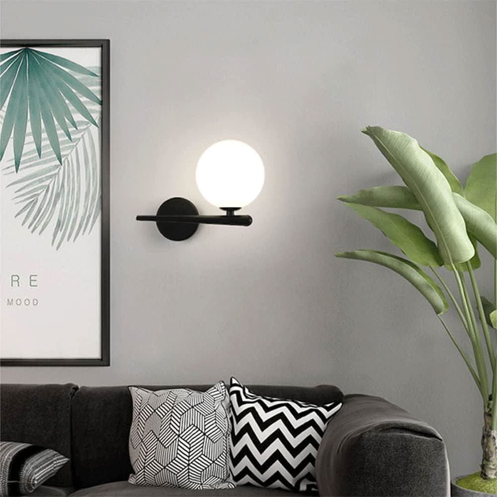 Version noire de l'applique, sphère lumineuse, toile encadrée et plante verte