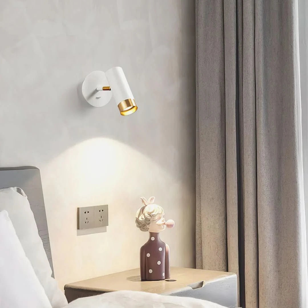 Mise en ambiance chambre claire, applique blanche éclairant le mur au-dessus du chevet