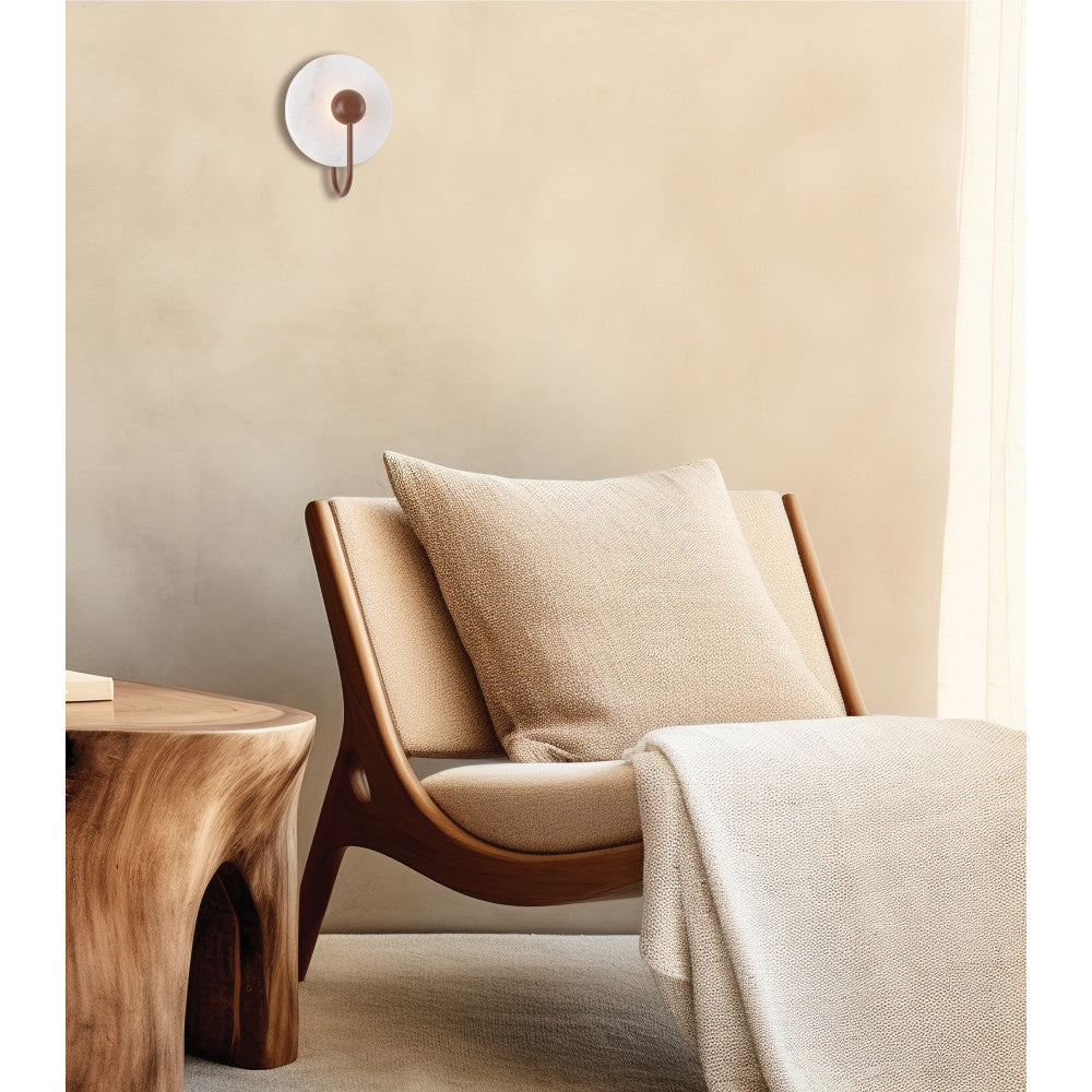 Applique murale fixée sur un mur beige au-dessus d'un fauteuil en bois.