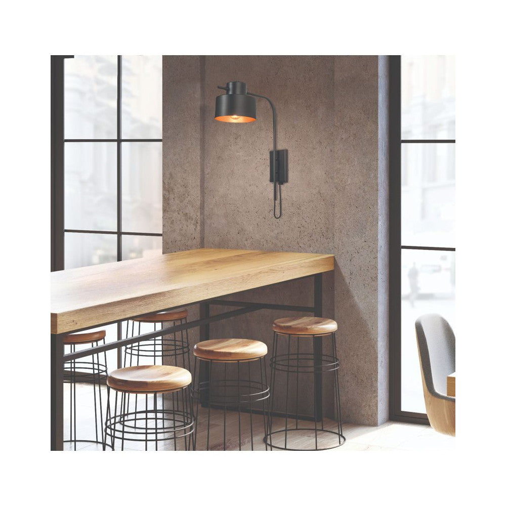 Mise en ambiance de l’applique noire au-dessus d’une table haute en bois.