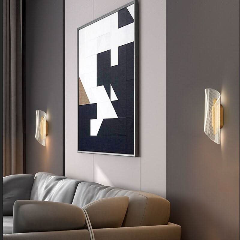 Mise en ambiance salon avec deux appliques encadrant une toile géométrique au-dessus du canapé