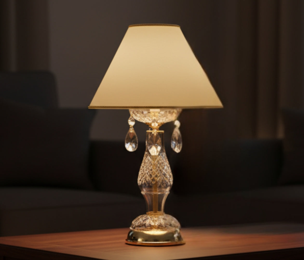 Lampe allumée posée sur une table en bois dans un intérieur sombre et feutré.