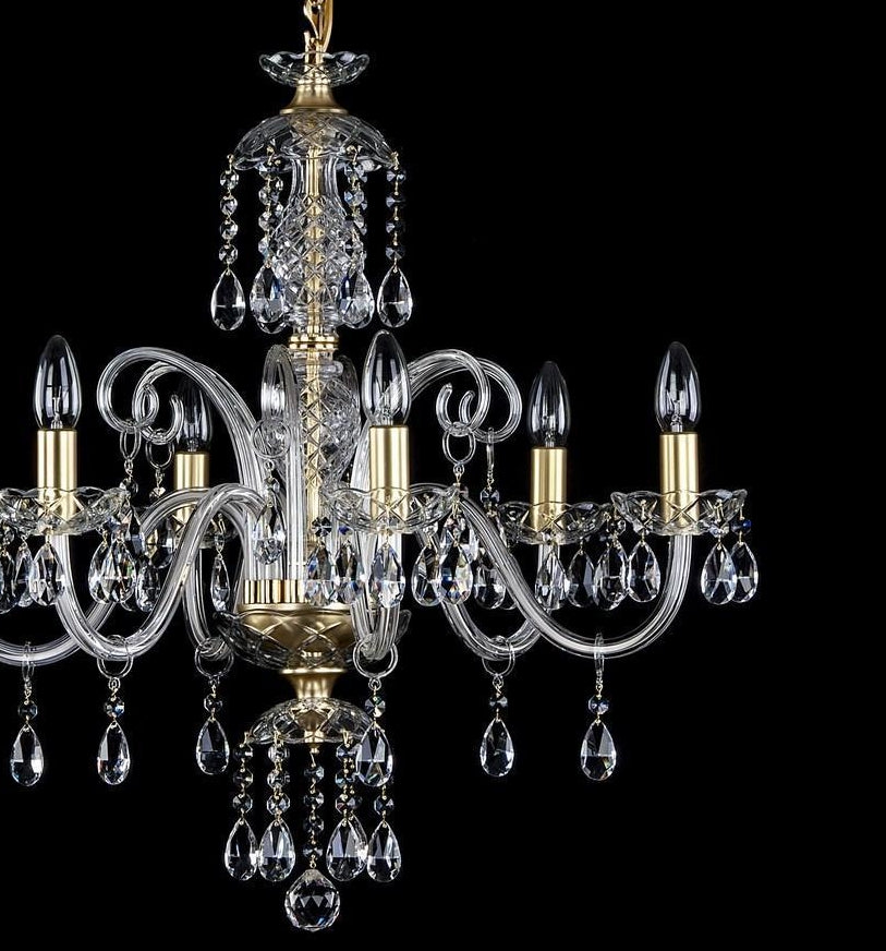 Vue de face du lustre doré, détails des bras torsadés et des pendentifs