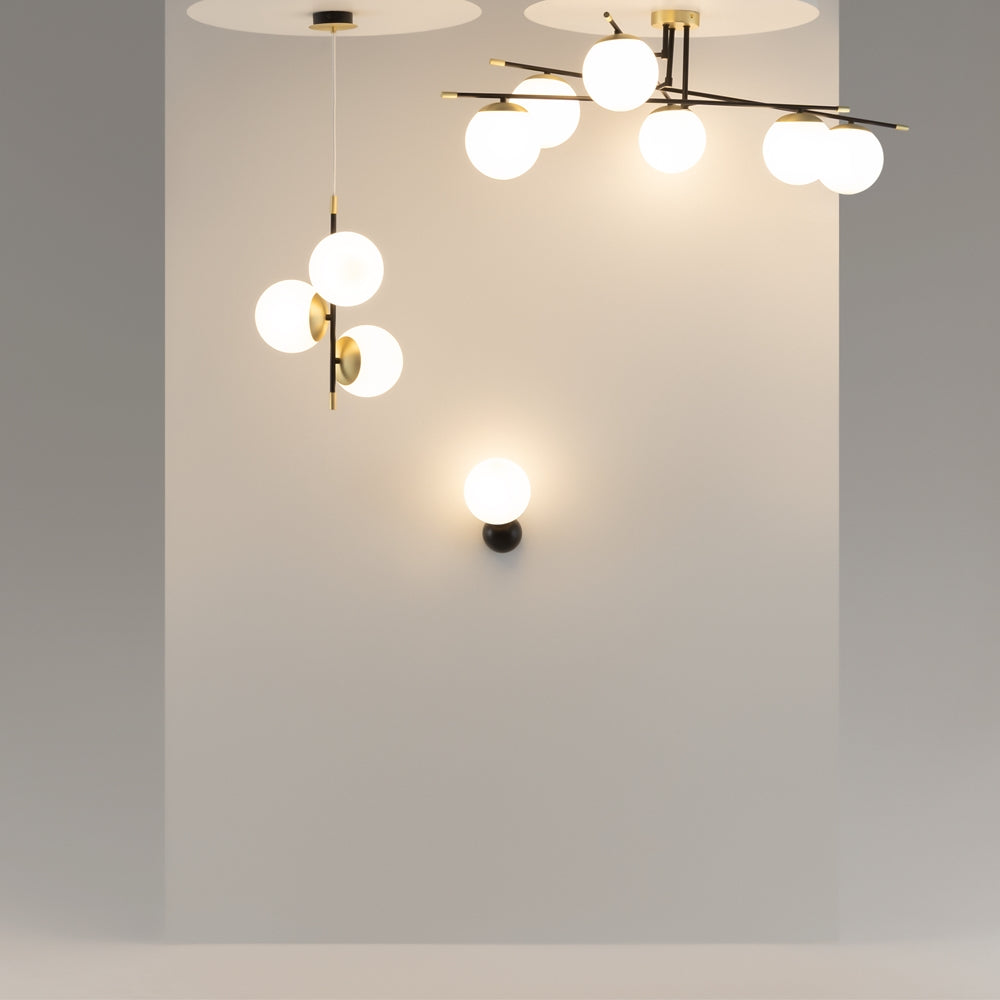 Mise en ambiance avec plusieurs suspensions et une applique dans une pièce claire