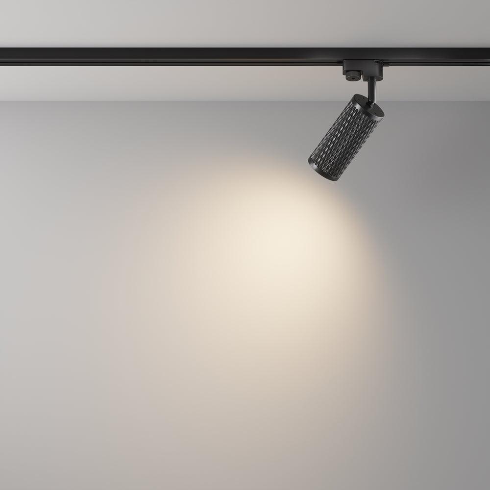 Mise en ambiance : le spot projette un halo de lumière chaude sur un mur gris.