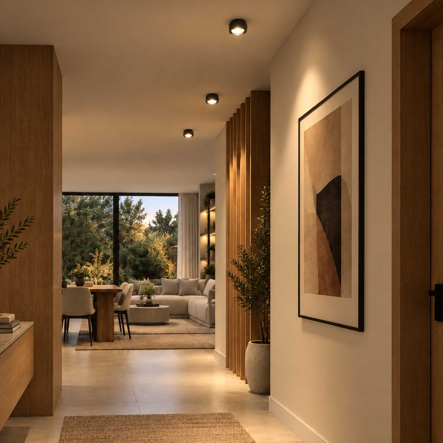 Ambiance de couloir avec trois spots noirs alignés au plafond, parquet clair