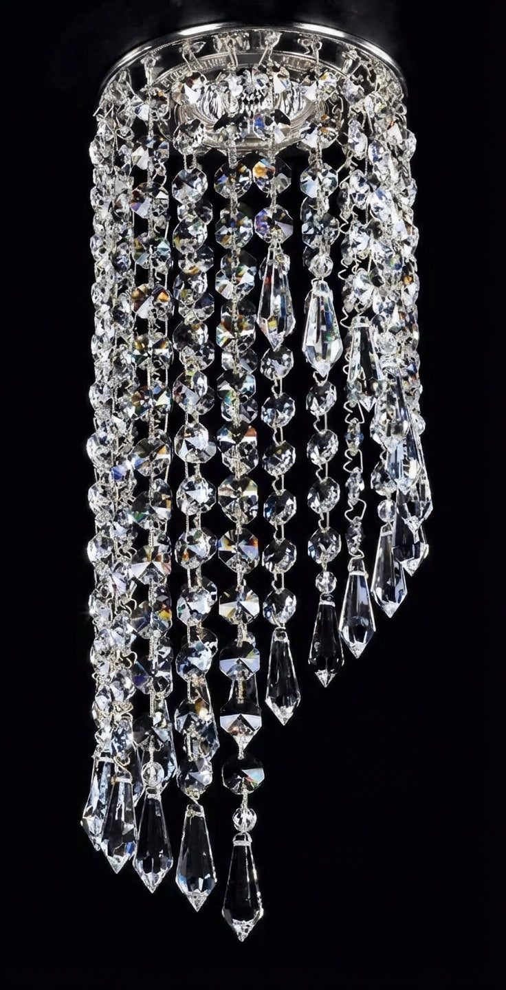 Gros plan sur les chaînes de cristal taillé et la monture dorée du luminaire