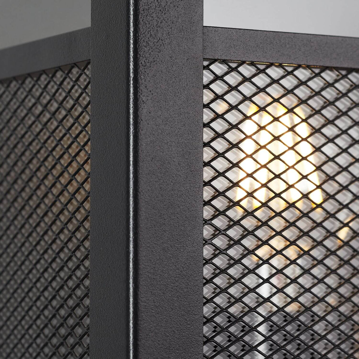 Gros plan sur l'armature métallique texturée et la grille alvéolée du luminaire