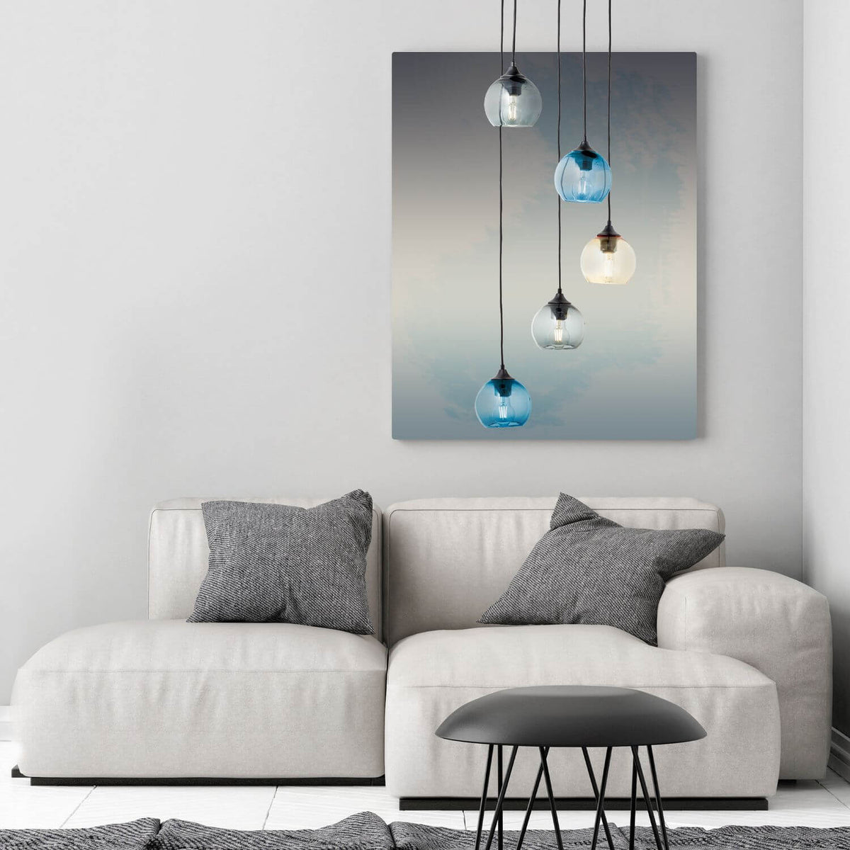 Vue en situation du luminaire au-dessus d'un canapé clair et d'une table basse.