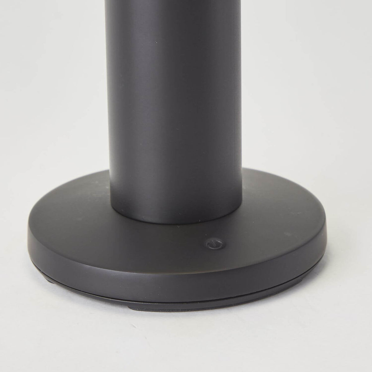 Gros plan du socle noir et de son bouton tactile central