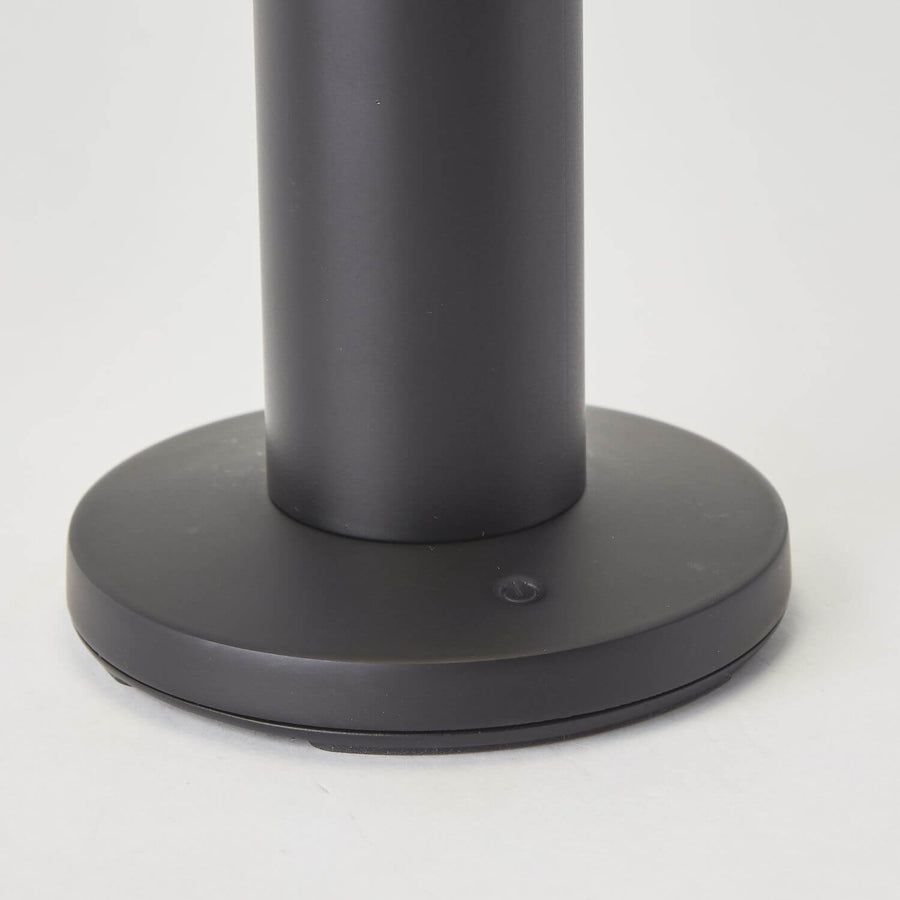 Gros plan du socle noir et de son bouton tactile central