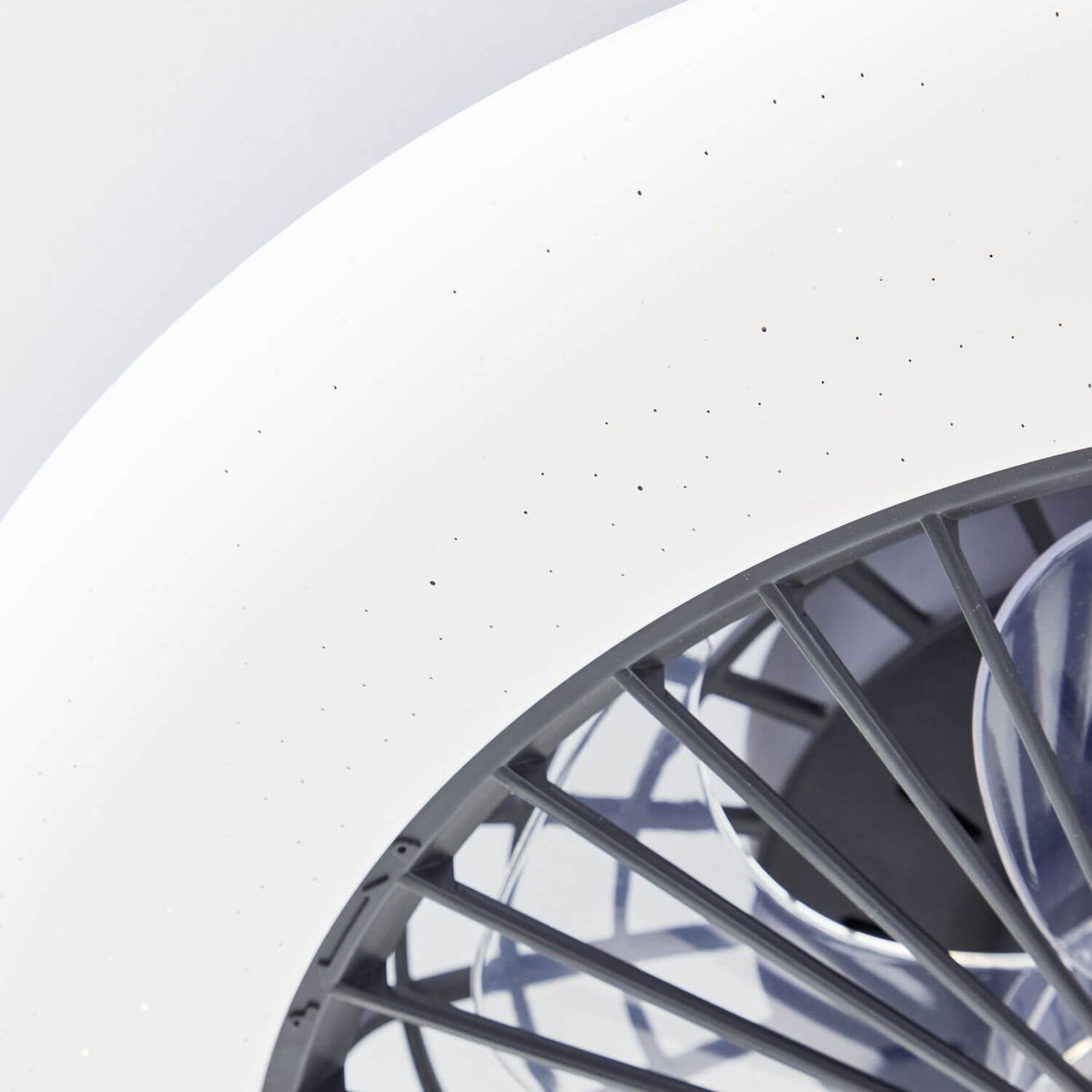 Détail rapproché du diffuseur blanc moucheté et du bord de la grille noire