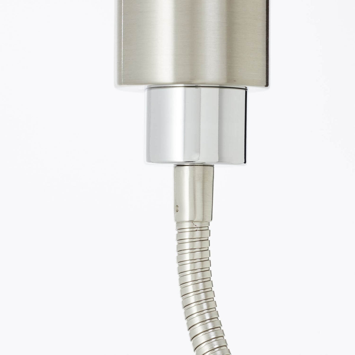 Détail de la tête cylindrique et du raccord chromé, finition brossée du métal.