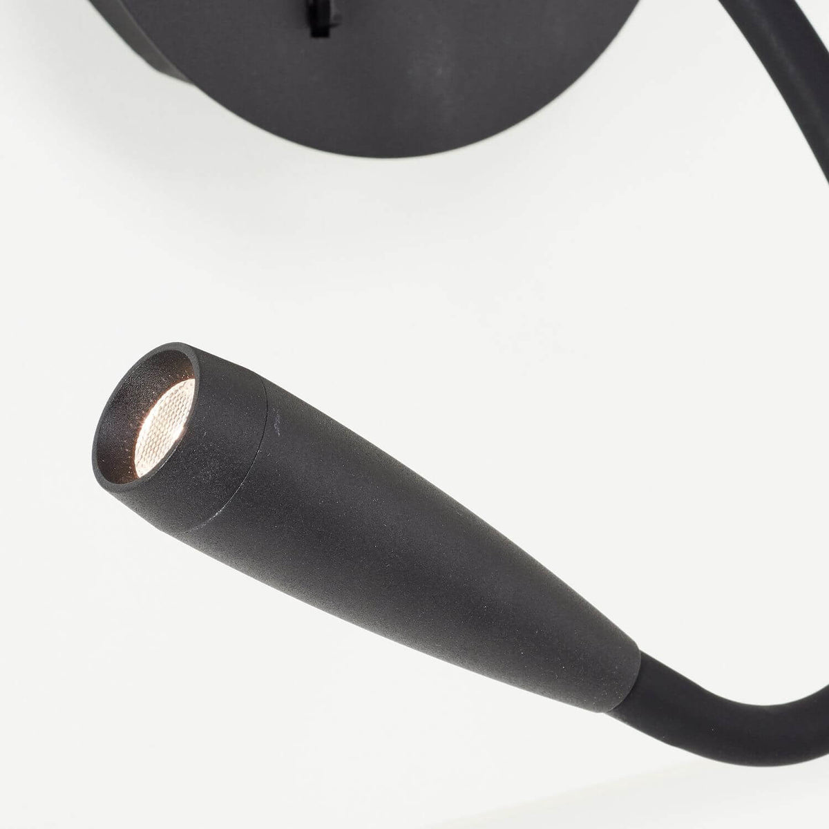 Gros plan sur la tête éclairante, lentille LED et finition noire mate.