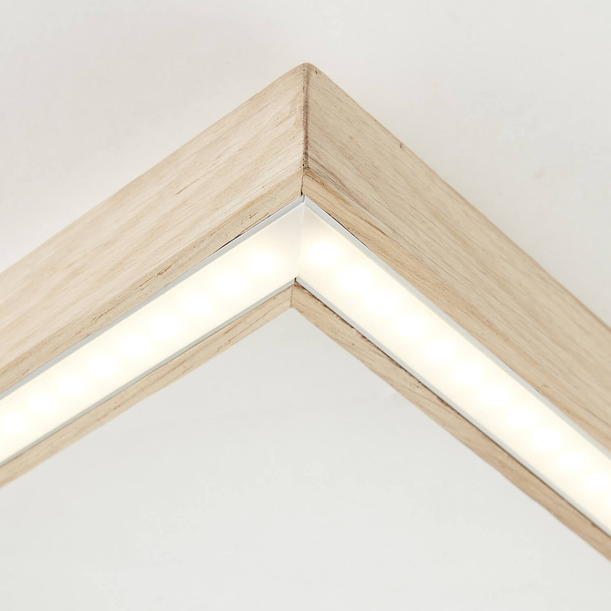 Détail rapproché d'un angle du cadre avec bandeau LED allumé