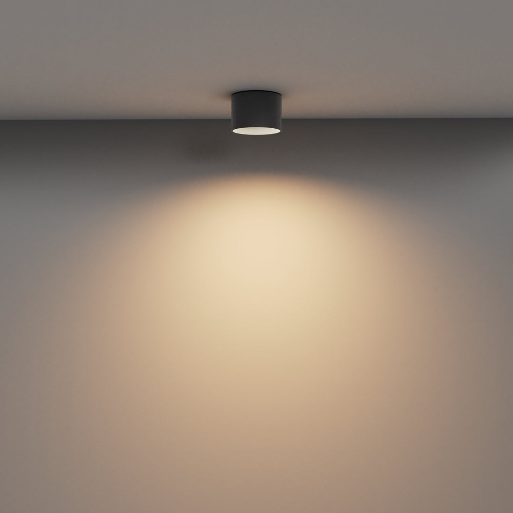 Mise en ambiance : halo lumineux chaud projeté sur le mur sous le plafonnier
