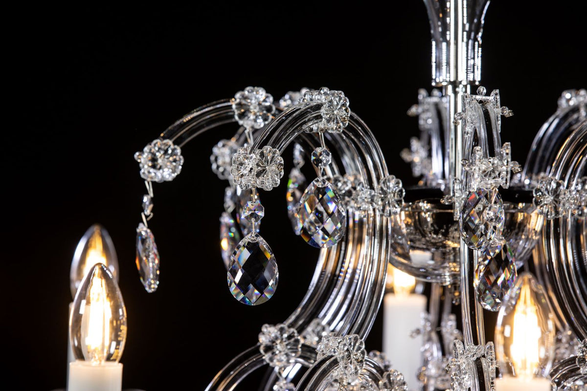 Détail des fleurs de cristal et pendentifs ovales accrochés aux bras incurvés