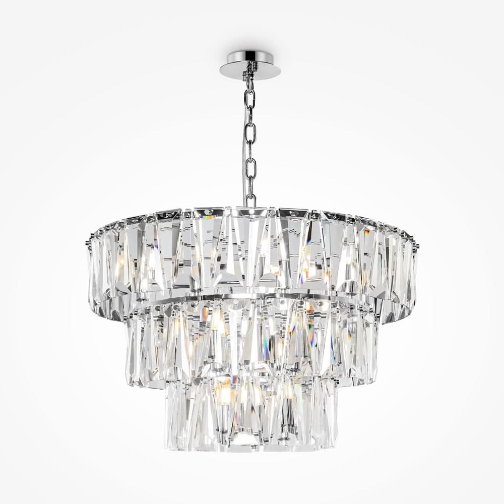 Version chromée de la suspension trois étages, éclairée, montrant les éclats lumineux des prismes.