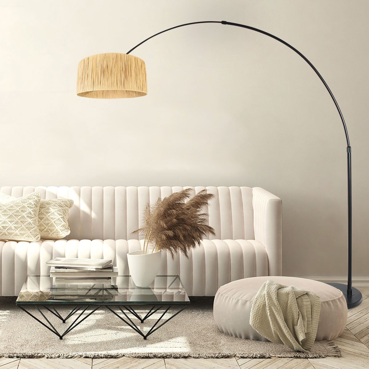 Lampadaire arc noir allumé au-dessus d'un canapé blanc, table basse et pouf en situation déco.