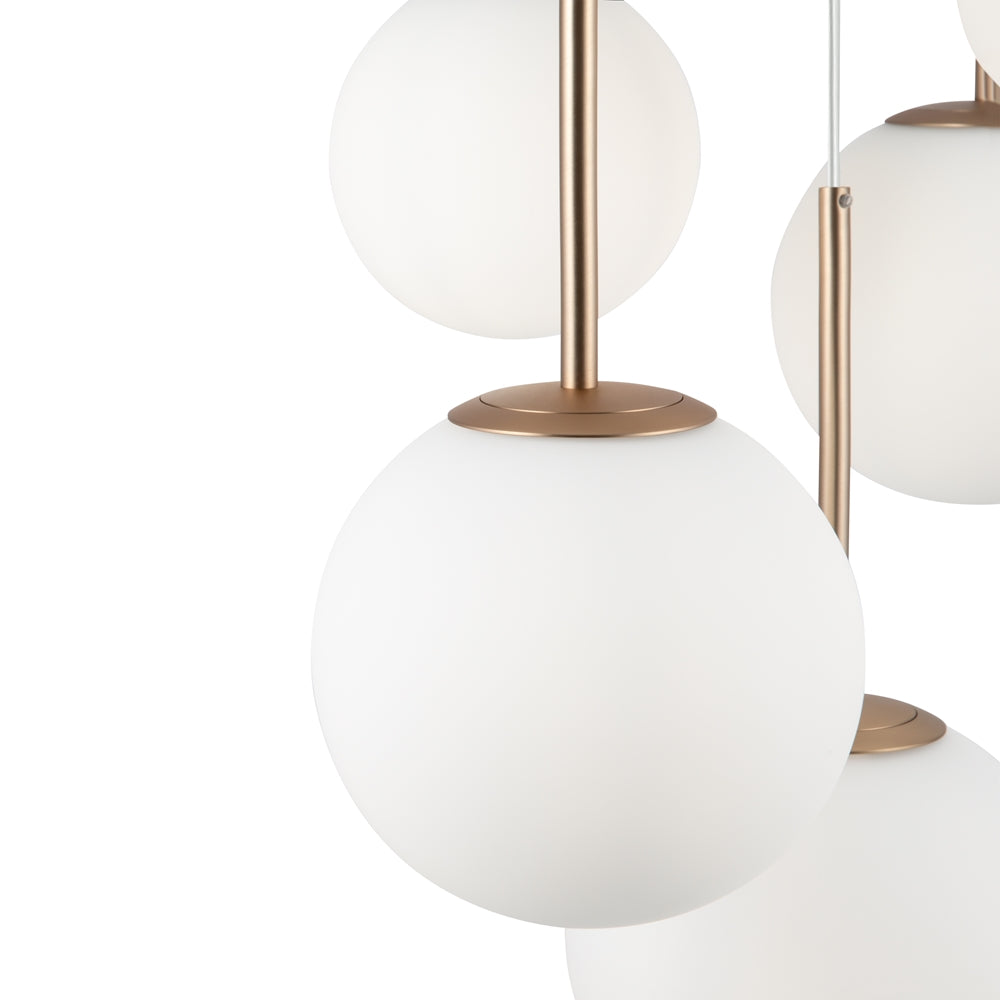 Vue rapprochée des globes, tiges dorées et câbles fins de suspension