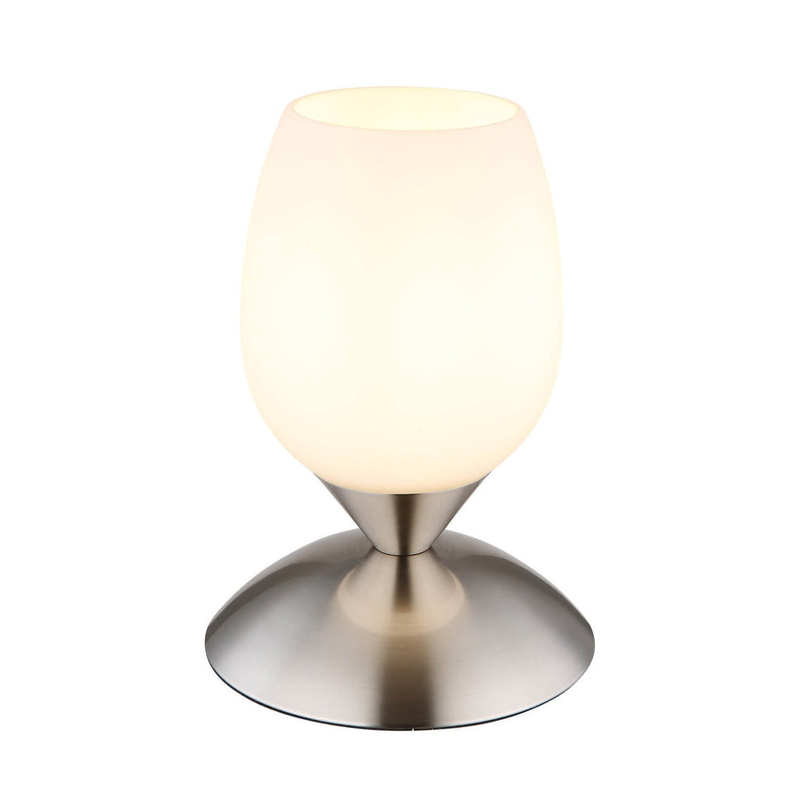 Lampe à poser allumée, abat-jour ovale en verre opalin, base nickel satiné.