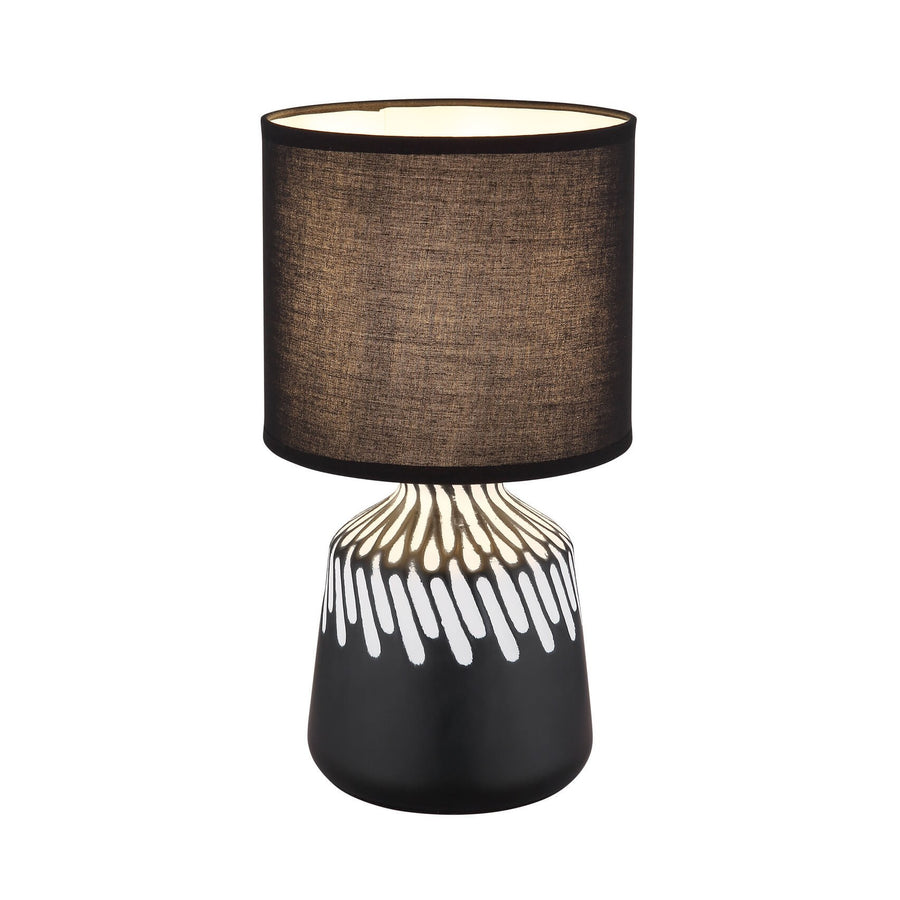 Lampe à poser noire de face, abat-jour cylindrique et base céramique à motif blanc