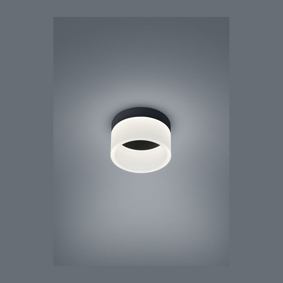 Plafonnier cylindrique noir et blanc photographié de face sur fond gris uni