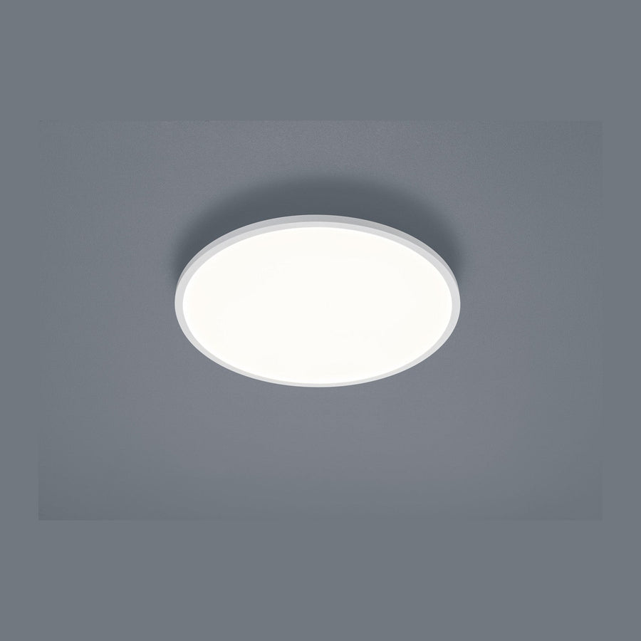 Plafonnier rond blanc fixé au plafond, vue de face sur fond gris