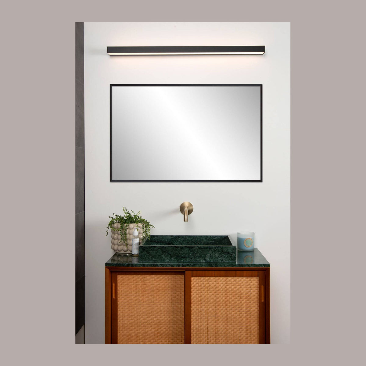 Applique murale noire allumée fixée au-dessus d'un miroir dans une salle de bain