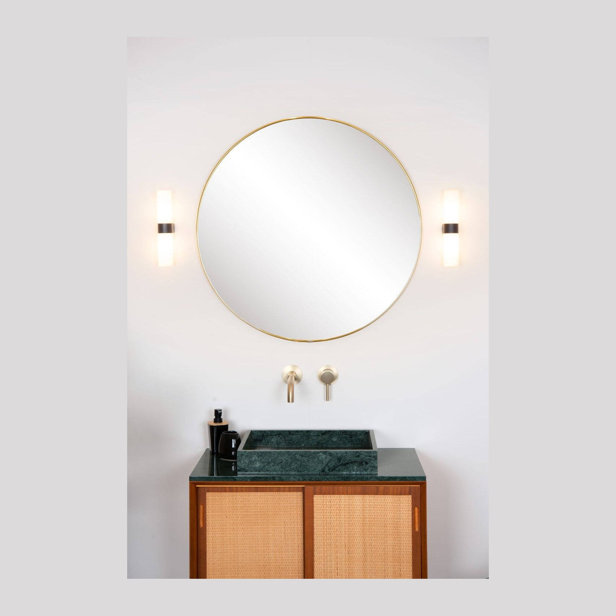 Vue d'ensemble d'une salle de bain avec deux appliques murales de part et d'autre du miroir