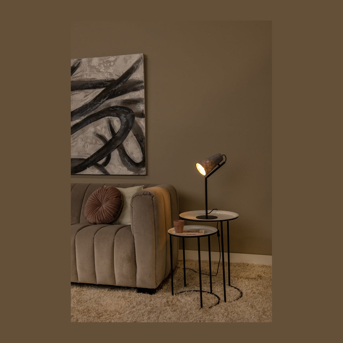 Lampe posée sur table d'appoint dans un salon au mur brun