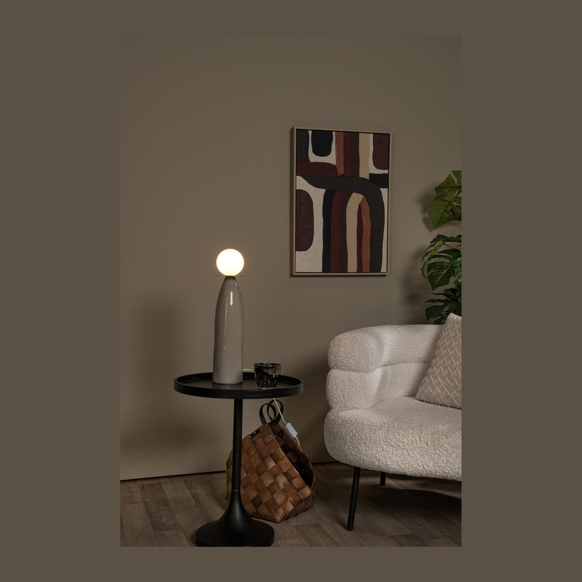 Lampe à poser allumée sur table d'appoint noire dans un salon