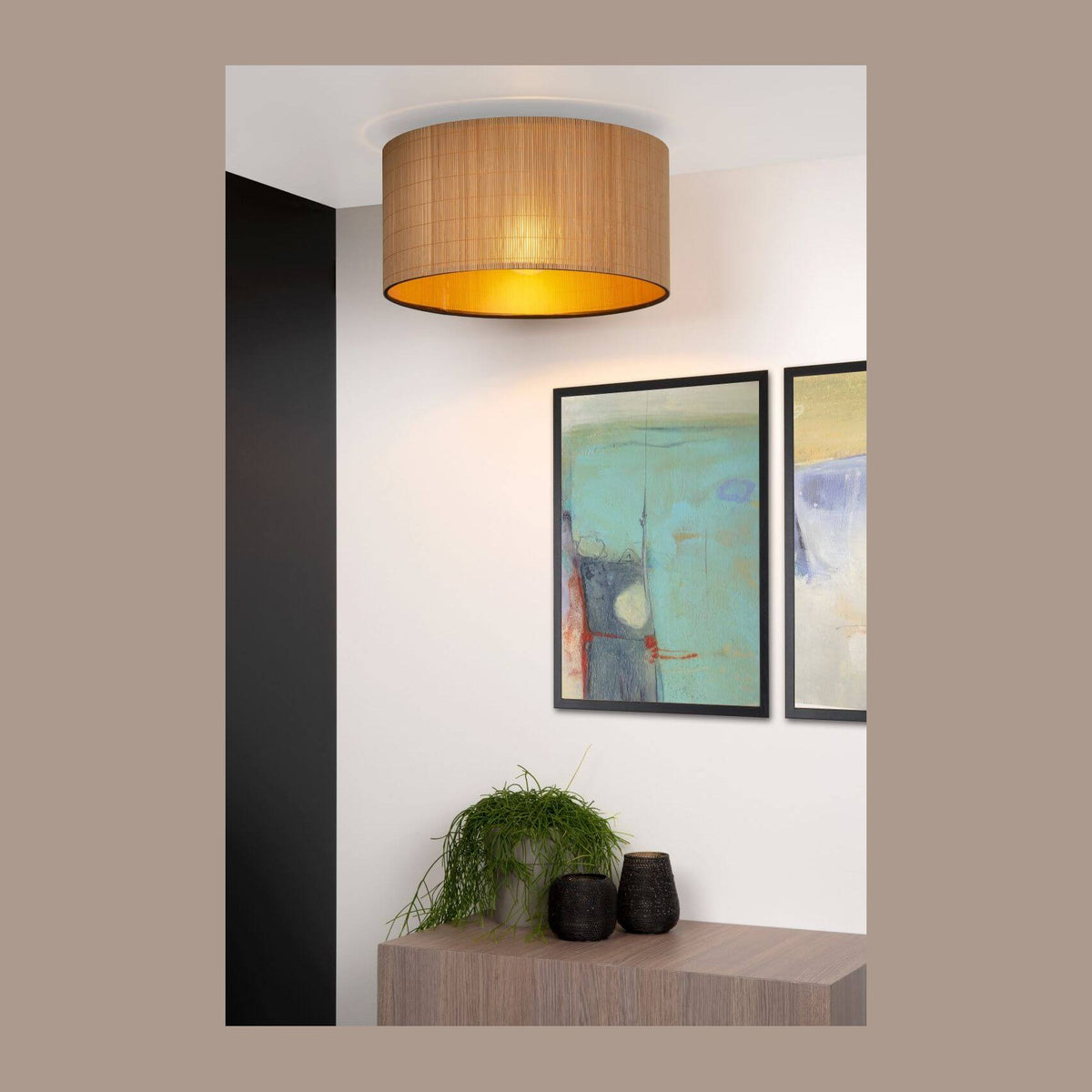Plafonnier cylindrique en rotin clair installé au plafond dans un salon contemporain.