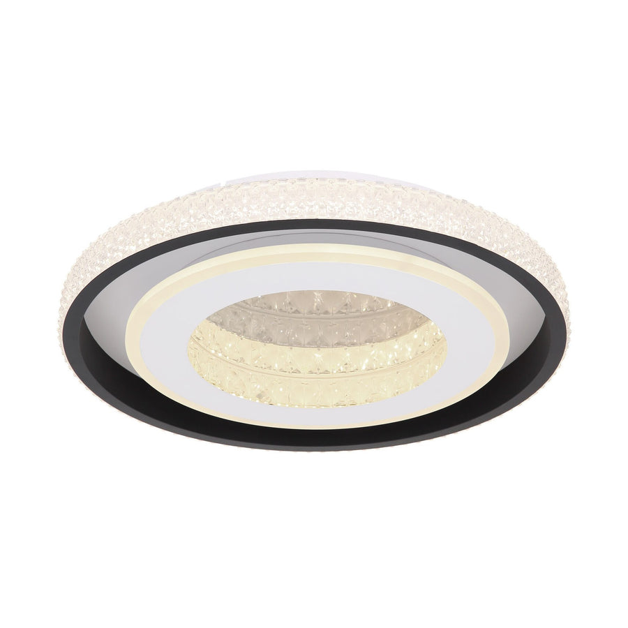 Vue de dessous du plafonnier rond allumé, anneaux noirs, blancs et verre cristal
