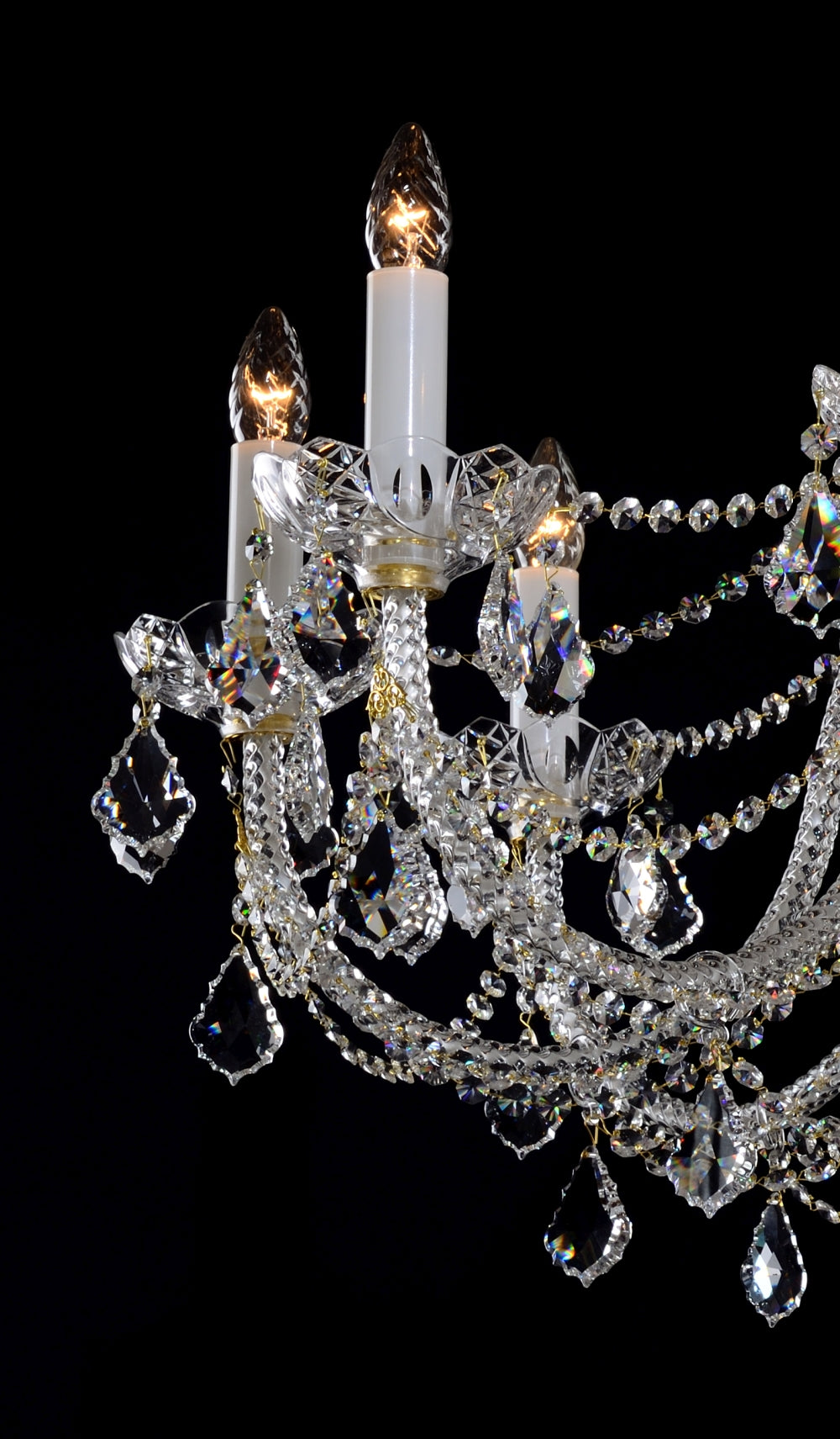Détail des bras dorés, manchons blancs et pendeloques en cristal taillé
